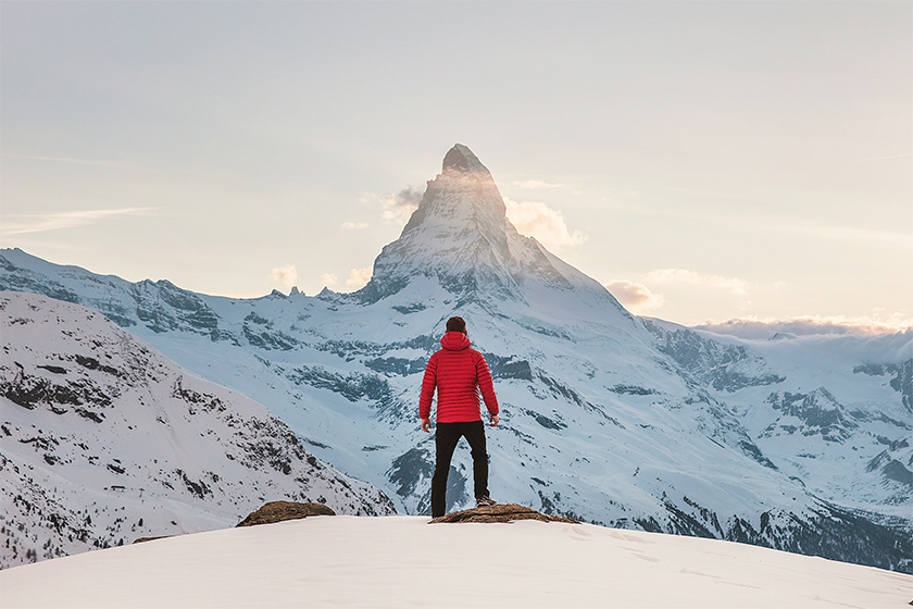 Homme de dos regardant une montagne enneigée