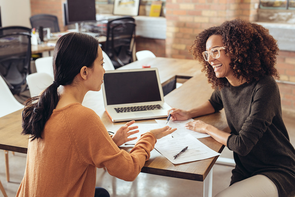 Deux femmes discutent une stratégie financière.