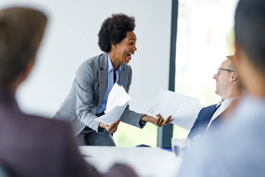 femme-affaires-bureau-collegues Une femme d’affaires partage son enthousiasme à ses collègues de bureau.