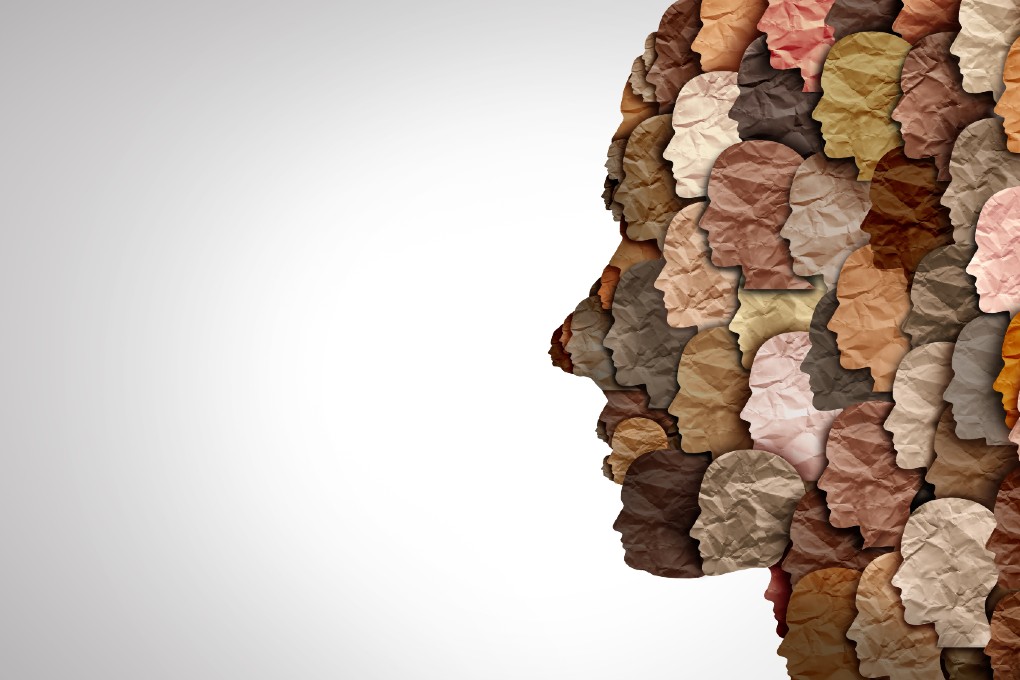 Photo d’un collage de visages en papier de couleurs différentes représentant la diversité 